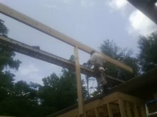 Carpenter setting a ridge beam over a new addition frame — Ice Dam Removal by Roofing Brothers in Palos Heights