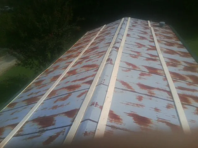 Rusted metal roof panels with new wood purlins before replacement — Storm Damage Roof Repair in Palos Heights by Roofing Brothers
