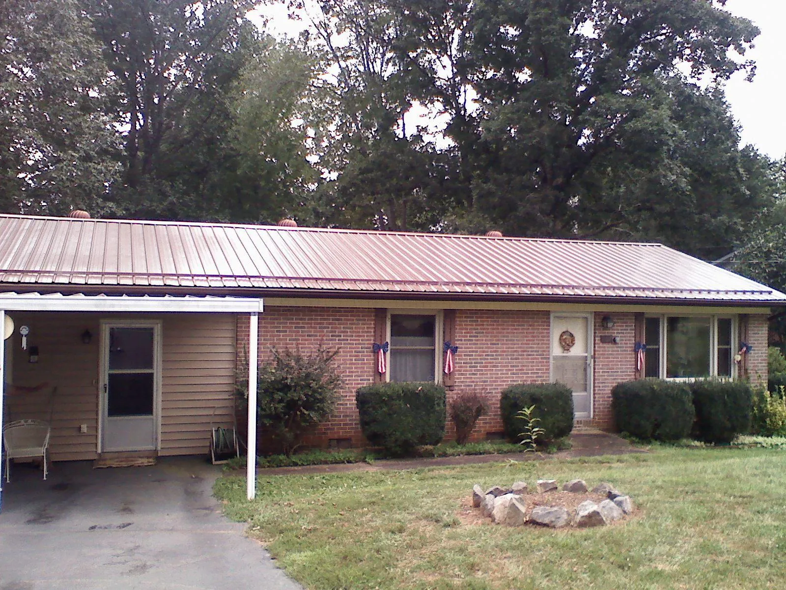 Bronze metal roof and carport on a brick ranch home — Roof Repair work by our crew in Palos Heights